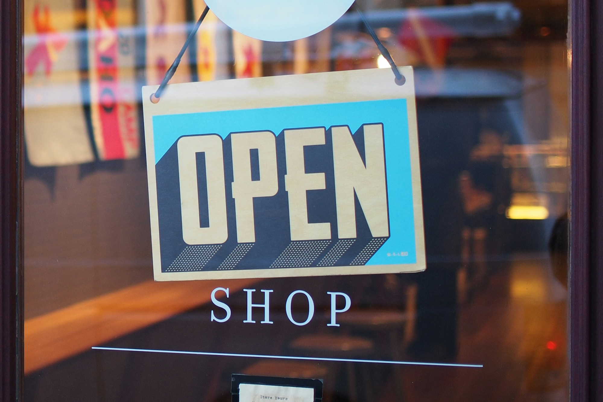 Open sign hanging in a small business shop window