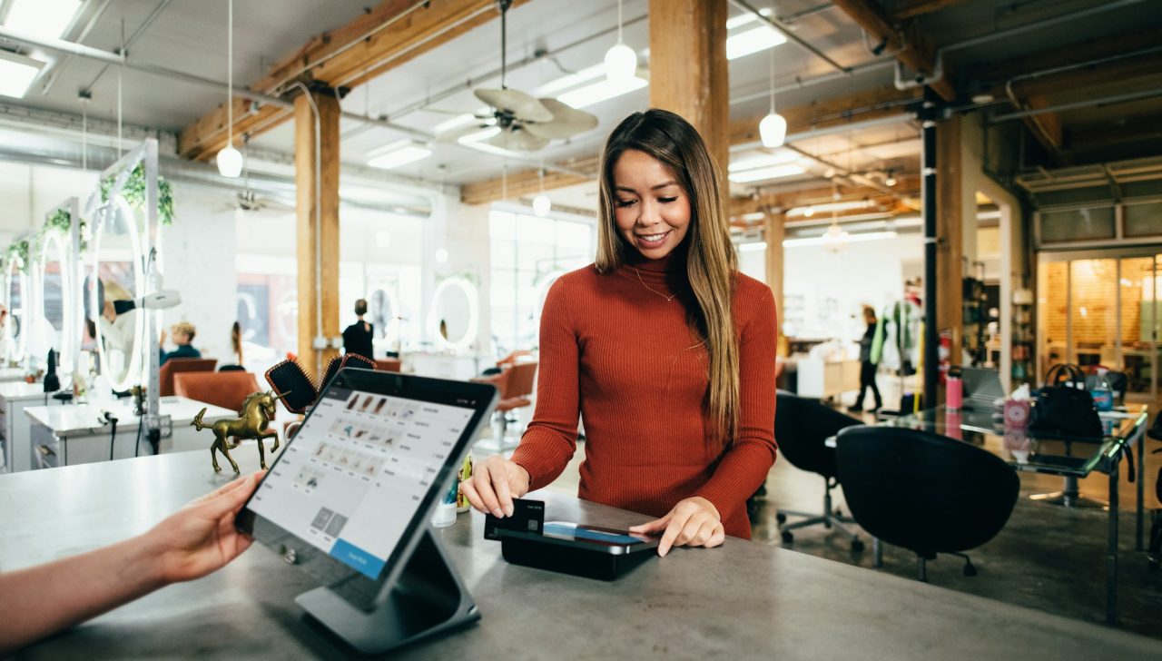 Retail assistant taking a card payment at a store checkout terminal