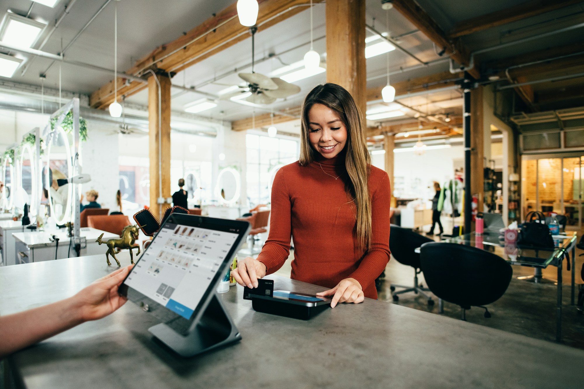 Retail assistant taking a card payment at a store checkout terminal